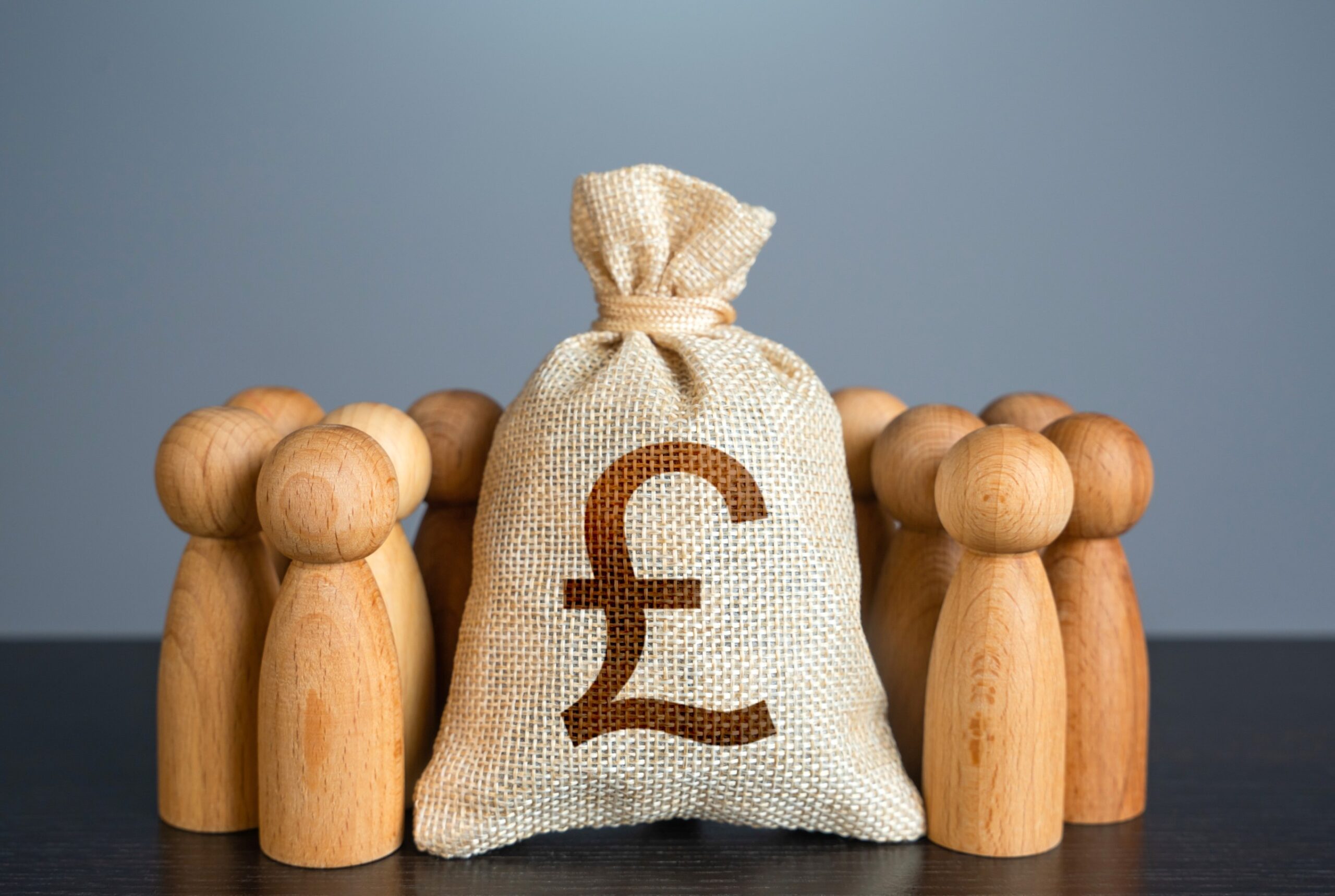 people-figures-stand-around-british-pound-sterling-BT3UDVX